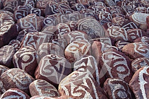 Pebbles from sacred Lake Manasarovar with hieroglyphs and main Buddhist mantra `Om Mani Padme Hum`.