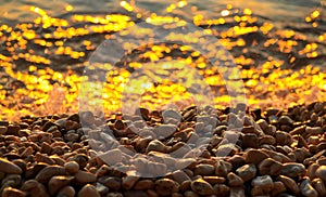 Pebbles and sea at sunset