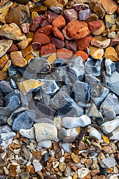 Pebbles and stones from a beach sorted into colours