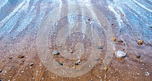 Pebbles or stones or rocks on beach at low tide. Seascape, nature, zen, tranquility concept wallpaper or background with copy