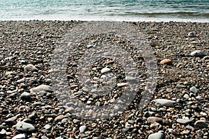 Pebbles, stones, rocks and seaweed on beach