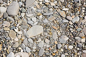 Pebbles in the sun. Small stones pebbles sand background.