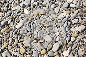 Pebbles in the sun. Small stones pebbles sand background.
