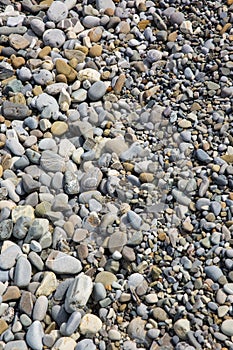 Pebbles in the sun. Small stones pebbles sand background.