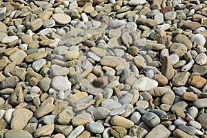 Pebbles in the sun. Small stones pebbles sand background.