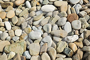 Pebbles in the sun. Small stones pebbles sand background.