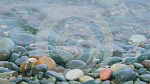 Pebbles Under The Surface Of The Water. Natural Background. Waves And Wet Pebbles. Close up.