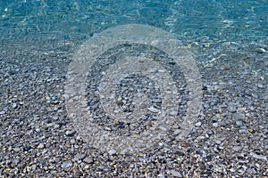 Pebbles under water. Marine background. Pure sea water. Clear sea