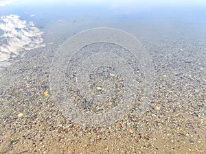 Pebbles in the water. Background, texture. Shallow Riverbed With Colorful Pebbles at Daytime