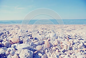 Pebbly beach on a sunny summer day, low angle view; faded, retro style