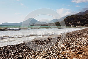 Pebbly beach sunset, mountains view. Montenegro.