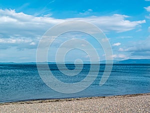 Peble beach blue sea hills and blue sky and cold day in Largs Scotland