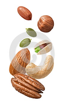 Pecan, almond, cashew, hazelnut, pistachio, peanut and green pumpkin seeds flying isolated on white background. Nuts falling for