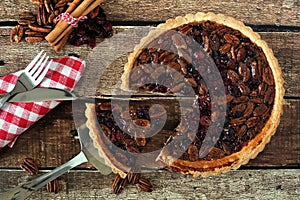 Pecan and cranberry pie, rustic table scene with slice removed