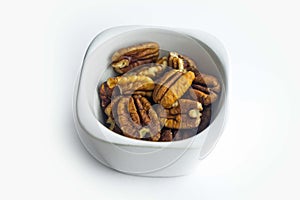 Pecan nuts in ceramic plate isolated on white background