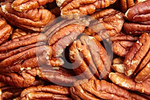 Pecan nuts kernel texture background closeup. Heap of peeled pecan halves. Admire the diversity of pecan textures