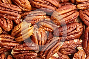 Pecan nuts kernel texture background closeup. Heap of peeled pecan halves. Pecan texture tells a natural tale