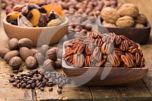 Pecan nuts peeled in wooden bowl on table, grunge style