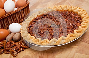 Pecan pie with ingredients on a cutting board