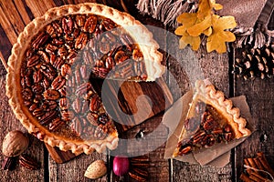 Pecan pie with slice removed, table scene over wood