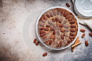 Pecan Pie on white dish, gray-brown background, top view. Vegan dessert concept