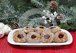 Pecan thumbprint cookies with raspberry jam in a Christmas setting.  Macro