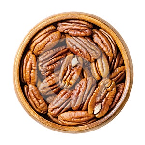 Pecans, raw pecan nut halves, snack nuts in a wooden bowl