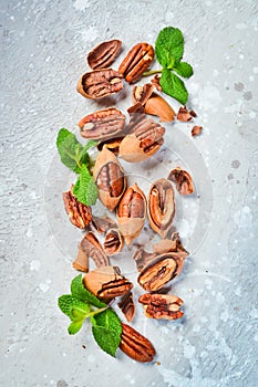 Pecans in shell on a stone background. Assortment of nuts.