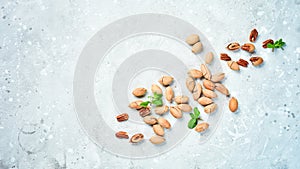Pecans in shell on a stone background. Assortment of nuts.
