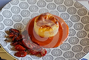 Pecorino cheese souffle on tomato sauce in decorated plate