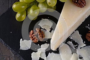 Pecorino romano, hard italian sheep milk cheese on black stone board, selective focus