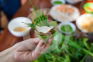 Peculiar herbs salad in Kon Tum, Vietnam. Using the leaves to make a cone-shaped container to put the food in, and use some bacon,