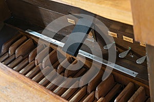 Pedalboard with pedals, swell coupler and feet controls in the pipe organ console, St. Mary`s Church of Gudow, Germany