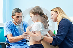 Pedeatrician african doctor examining little girl with stethoscope