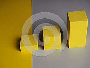 Pedestal squares shadows on a yellow and gray background