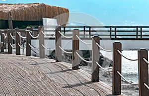Pedestrian bridge along the coast with a fence with a rope. Sea summer landscape background