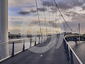 Pedestrian bridge in Amsterdam at sunrise summer