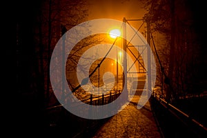 Pedestrian bridge in dense fog at night