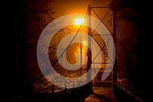 Pedestrian bridge in dense fog at night