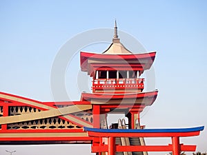 A pedestrian bridge finished in traditional Japanese architectural style, the bridge is served with electric stairs