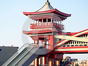 A pedestrian bridge finished in traditional Japanese architectural style, the bridge is served with electric stairs