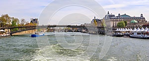 Pedestrian bridge Passerelle LÃÂ©opold-SÃÂ©dar-Senghor over Seine river, boats and historic buildings of Paris France