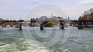 Pedestrian bridge Pont des Arts over Seine river and historic buildings of Paris France