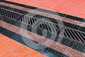 Pedestrian covering, lined with granite tiles with metal drainage grate