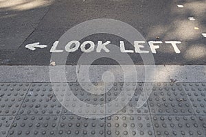 Pedestrian crossing with markings look left on the road to help tourist to look at the right direction