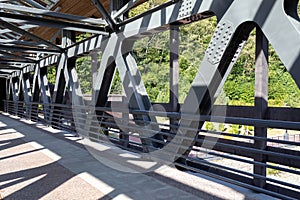 Pedestrian crossing over a river or highway. Covered bridge across the road. Bridge beams made of steel. Construction of