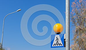 pedestrian crossing road sign on a background of blue sky. warning sign for drivers.