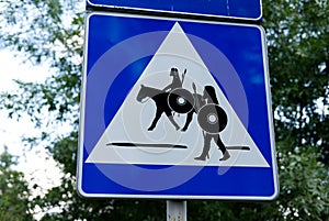 Pedestrian crossing road sign for knights and warriors on horses marking a reenactment battle between medieval knights