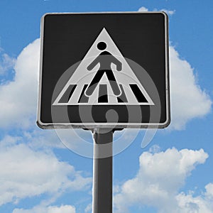 Pedestrian crossing sign isolated against the sky