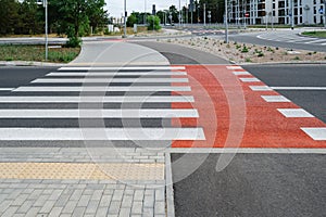 Pedestrian crossing with white stripes on asphalt and marking for bicycle lane